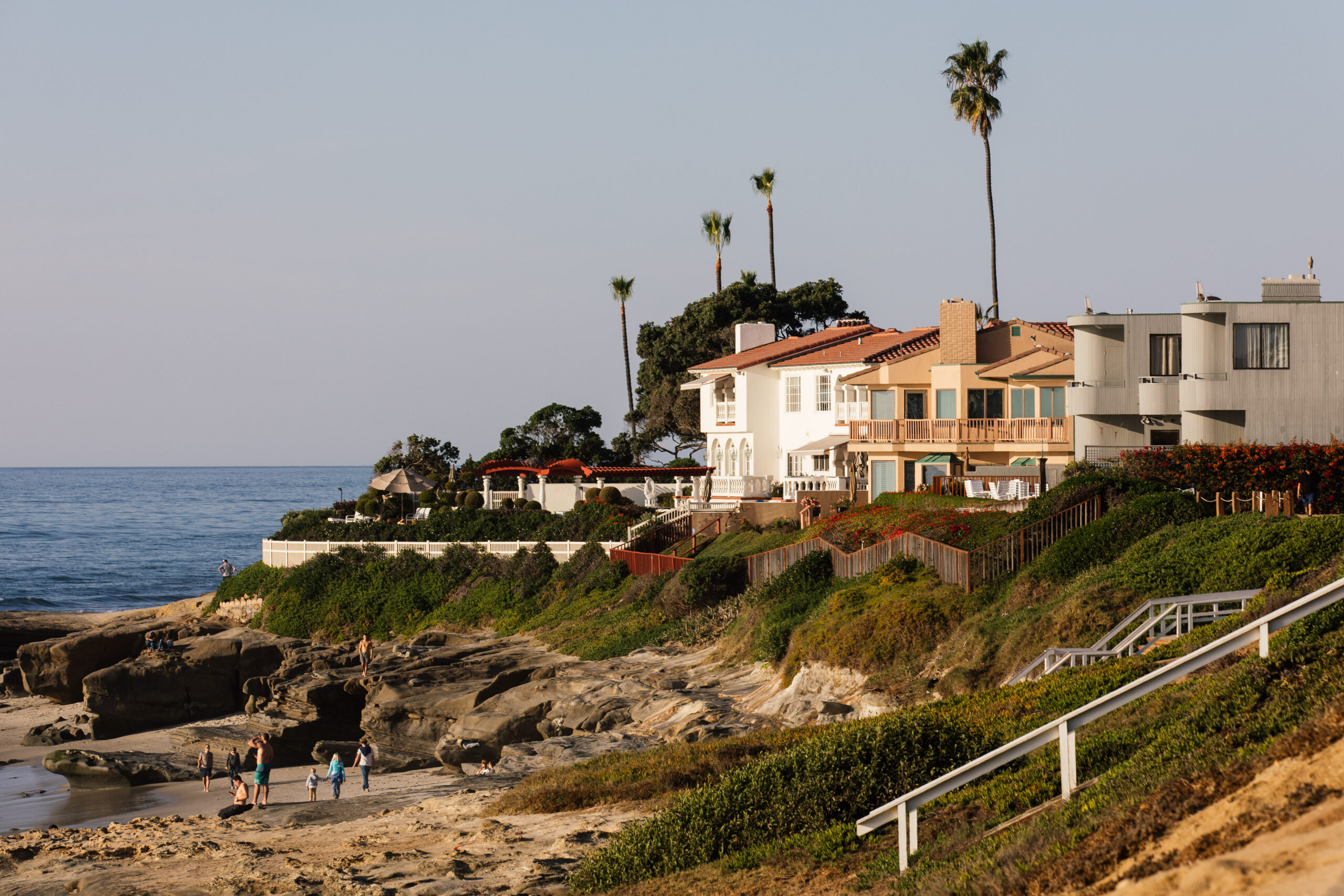 Luxury San Diego million dollar homes situated on a coastal bluff overlooking the rocky beach and ocean in La Jolla.